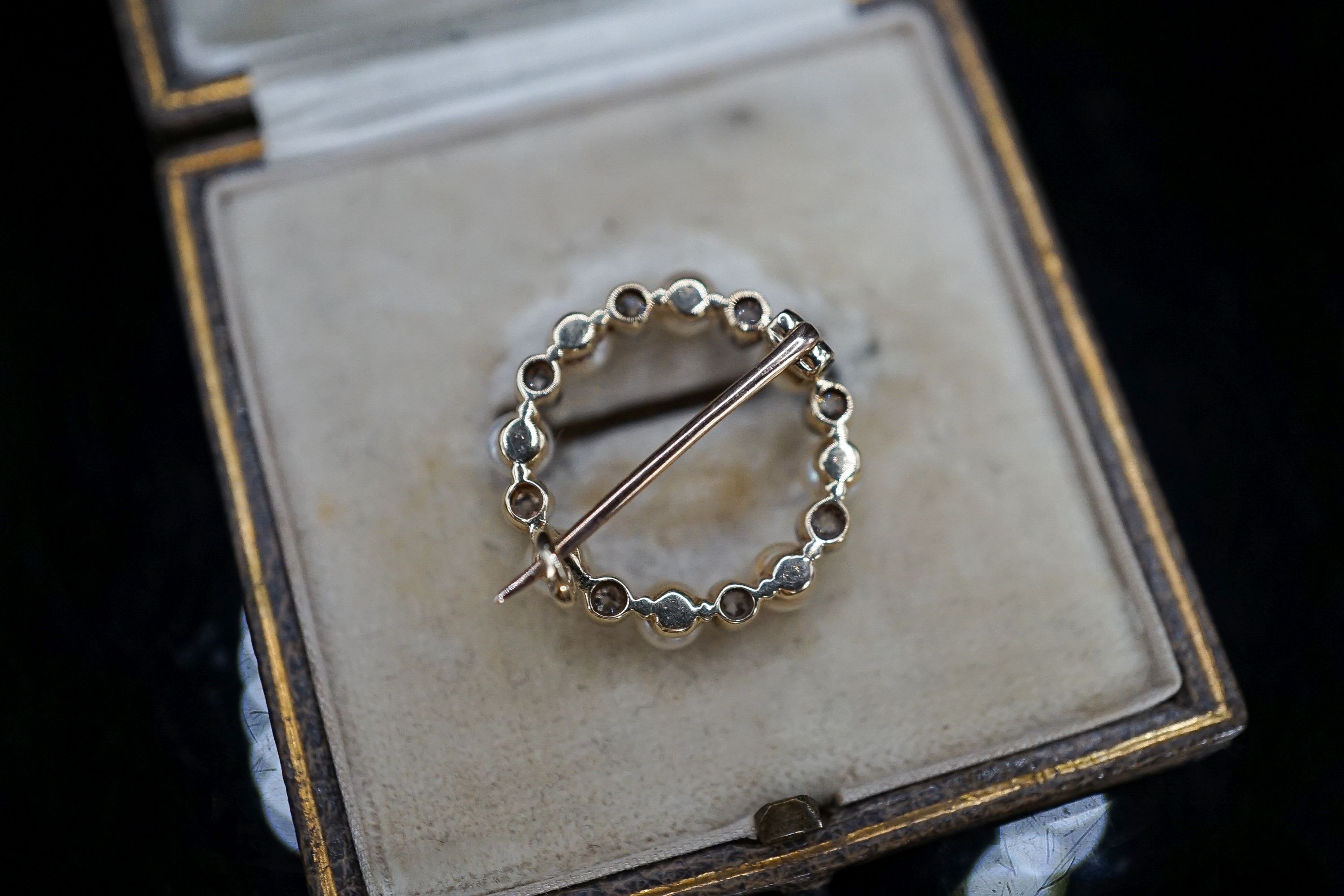 An Edwardian yellow metal, diamond and seed pearl set open work circular brooch, 20mm, gross 2.9 grams.